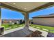Inviting covered patio with synthetic grass, integrated pavers, seating, and mountain views at 54 Mirage View Dr, Henderson, NV 89011