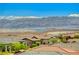 Lake view from the rooftop featuring mountains, blue skies, and nearby luxury homes, complemented by lush landscaping at 54 Mirage View Dr, Henderson, NV 89011