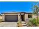 A front exterior featuring desert landscaping, a large front window, and a two-car garage at 54 Mirage View Dr, Henderson, NV 89011