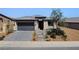 Charming single-story home with a well-kept lawn, desert landscaping, and a two-car garage at 54 Mirage View Dr, Henderson, NV 89011