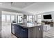 Modern kitchen island with stone countertop and seating overlooking the living area and mountain views at 54 Mirage View Dr, Henderson, NV 89011