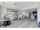Bright living room features wood floors, recessed lights, and sliding glass doors to the patio and views to kitchen at 54 Mirage View Dr, Henderson, NV 89011