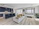 Open-concept living room and kitchen featuring stylish furniture and expansive windows with views of the surrounding landscape at 54 Mirage View Dr, Henderson, NV 89011