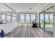 Bright living room with wood floors and views to mountains through three large windows and a sliding glass door at 54 Mirage View Dr, Henderson, NV 89011