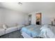 Bright main bedroom with contemporary decor, including couch, ensuite bath access, and gray carpet at 54 Mirage View Dr, Henderson, NV 89011