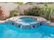 Close up of a beautiful jacuzzi with blue tile detailing, palm trees, and landscaping at 5404 Ireland St, Las Vegas, NV 89149