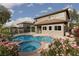 A swimming pool and jacuzzi are surrounded by pink flowers, a small fence, and shade umbrella at 5404 Ireland St, Las Vegas, NV 89149