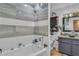 Bright bathroom with a soaking tub, tiled walls, and stylish blue vanity at 5424 Neosho St, Las Vegas, NV 89120