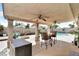 Inviting covered patio features ceiling fans, a dining set, and views of the sparkling pool, perfect for outdoor entertaining at 5424 Neosho St, Las Vegas, NV 89120