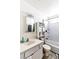 Small bathroom with toilet, tub, shower, mirror, and white cabinet at 5600 W Bartlett Ave, Las Vegas, NV 89108