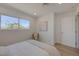 Bright bedroom with a large window, comfortable bed, and stylish chair and abstract art at 5904 Apple Valley Ln, Las Vegas, NV 89108