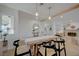 Bright dining area featuring a wooden table, modern lighting, and views into the living room with fireplace at 5904 Apple Valley Ln, Las Vegas, NV 89108