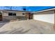 Exterior view of single-story home with a pink front door, landscaping and a large driveway at 5904 Apple Valley Ln, Las Vegas, NV 89108