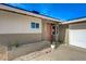 View of house exterior showcasing the front door, landscaping, and attached garage at 5904 Apple Valley Ln, Las Vegas, NV 89108