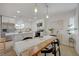 Modern kitchen with island and dining area illuminated by pendant lights at 5904 Apple Valley Ln, Las Vegas, NV 89108