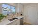 Kitchen sink with a large window, stylish faucet, quartz countertops, and white cabinets at 5904 Apple Valley Ln, Las Vegas, NV 89108