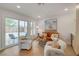 Bright living room with light hardwood floors, a sliding glass door, neutral decor, and modern furnishings at 5904 Apple Valley Ln, Las Vegas, NV 89108