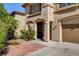 Inviting home entrance featuring a covered entryway with lovely landscaping and a brick-paved walkway at 6032 S Pioneer Way, Las Vegas, NV 89113