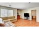 Cozy living room with hardwood floors, a sofa, TV, and a window at 6032 S Pioneer Way, Las Vegas, NV 89113