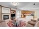Comfortable living room with a fireplace, mounted TV, and a kitchen view with modern appliances at 6032 S Pioneer Way, Las Vegas, NV 89113