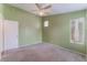 Bright bedroom featuring neutral green walls, carpet floors, and a ceiling fan at 6056 Flowering Plum Ave, Las Vegas, NV 89142