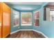 Dining area with large windows providing natural light, with blue walls, and hardwood floors at 6056 Flowering Plum Ave, Las Vegas, NV 89142