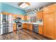 Bright kitchen with stainless steel appliances, light wood cabinets, and vibrant accent paint at 6056 Flowering Plum Ave, Las Vegas, NV 89142