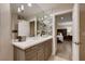 Well-lit bathroom vanity featuring a quartz countertop, wood-look cabinets, and a modern lighting fixture at 6316 Bluejay Way, Las Vegas, NV 89146