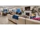 Open-concept living room and kitchen with a large sectional sofa, fireplace, and breakfast bar seating at 6316 Bluejay Way, Las Vegas, NV 89146