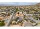 Aerial view showcases a neighborhood with various home styles, mature trees, and mountain views in the distance at 6520 Turtle Hill Rd, Las Vegas, NV 89110