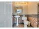 Cozy half bathroom with a pedestal sink, toilet, decorative mirror, and stylish tile accents at 6520 Turtle Hill Rd, Las Vegas, NV 89110