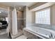 Stylish bathroom showcasing a jetted tub, glass block window, and walk-in shower at 6520 Turtle Hill Rd, Las Vegas, NV 89110