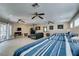 Spacious bedroom with three beds, tile flooring, ceiling fans, and sliding glass door access at 6520 Turtle Hill Rd, Las Vegas, NV 89110