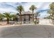 Pristine home with manicured landscaping, stone accents, a gated entrance, and tall palm trees at 6520 Turtle Hill Rd, Las Vegas, NV 89110