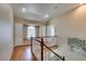 Well-lit hallway showcasing hardwood floors, a window seat, and a staircase with wooden handrails at 6520 Turtle Hill Rd, Las Vegas, NV 89110