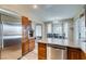 Open concept kitchen with stainless steel appliances, wood cabinets, granite countertops, and dining area at 6520 Turtle Hill Rd, Las Vegas, NV 89110