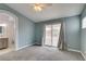This carpeted main bedroom has a ceiling fan and sliding glass doors leading to the yard at 709 Heritage Point Dr, Henderson, NV 89002