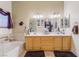 This bathroom has a double sink vanity with a bathtub and shower in the background at 7517 Elk Meadows Ct, Las Vegas, NV 89131