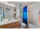 Well-lit bathroom with a single sink, mirror, and a bathtub with bright blue shower curtain at 7517 Elk Meadows Ct, Las Vegas, NV 89131