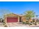 Well-maintained single-story home with desert landscaping, a brick driveway, and a red garage door at 7902 Jessamy St, North Las Vegas, NV 89084