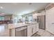 Modern kitchen with stainless steel appliances and an island overlooking the living and dining areas at 7902 Jessamy St, North Las Vegas, NV 89084