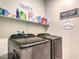 Convenient laundry room with modern washer and dryer set, ample shelving, and laundry-themed wall decor at 7902 Jessamy St, North Las Vegas, NV 89084