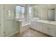 Bathroom with glass shower, separate tub, and double sink vanity with white cabinets at 8084 Black Orchid Ave, Las Vegas, NV 89131