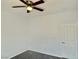 A well-lit bedroom featuring a ceiling fan, gray carpet, and a white door at 8084 Black Orchid Ave, Las Vegas, NV 89131