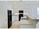 Modern kitchen with white cabinets, black appliances, breakfast bar, and tile flooring at 8084 Black Orchid Ave, Las Vegas, NV 89131