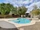 Backyard pool surrounded by rock landscaping and tall privacy trees at 8084 Black Orchid Ave, Las Vegas, NV 89131