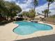 Large in-ground pool and spa in backyard with mature trees and tropical palm trees in the background at 8084 Black Orchid Ave, Las Vegas, NV 89131