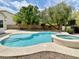 Beautiful backyard pool and spa surrounded by a concrete patio and mature landscaping at 8084 Black Orchid Ave, Las Vegas, NV 89131