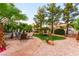 Backyard with manicured gravel, green grass, lounge areas and mature trees at 8117 Horizon Lake Dr, Las Vegas, NV 89128