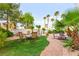 Private backyard featuring a stone path, artificial turf, palm trees, and an outdoor seating area at 8117 Horizon Lake Dr, Las Vegas, NV 89128